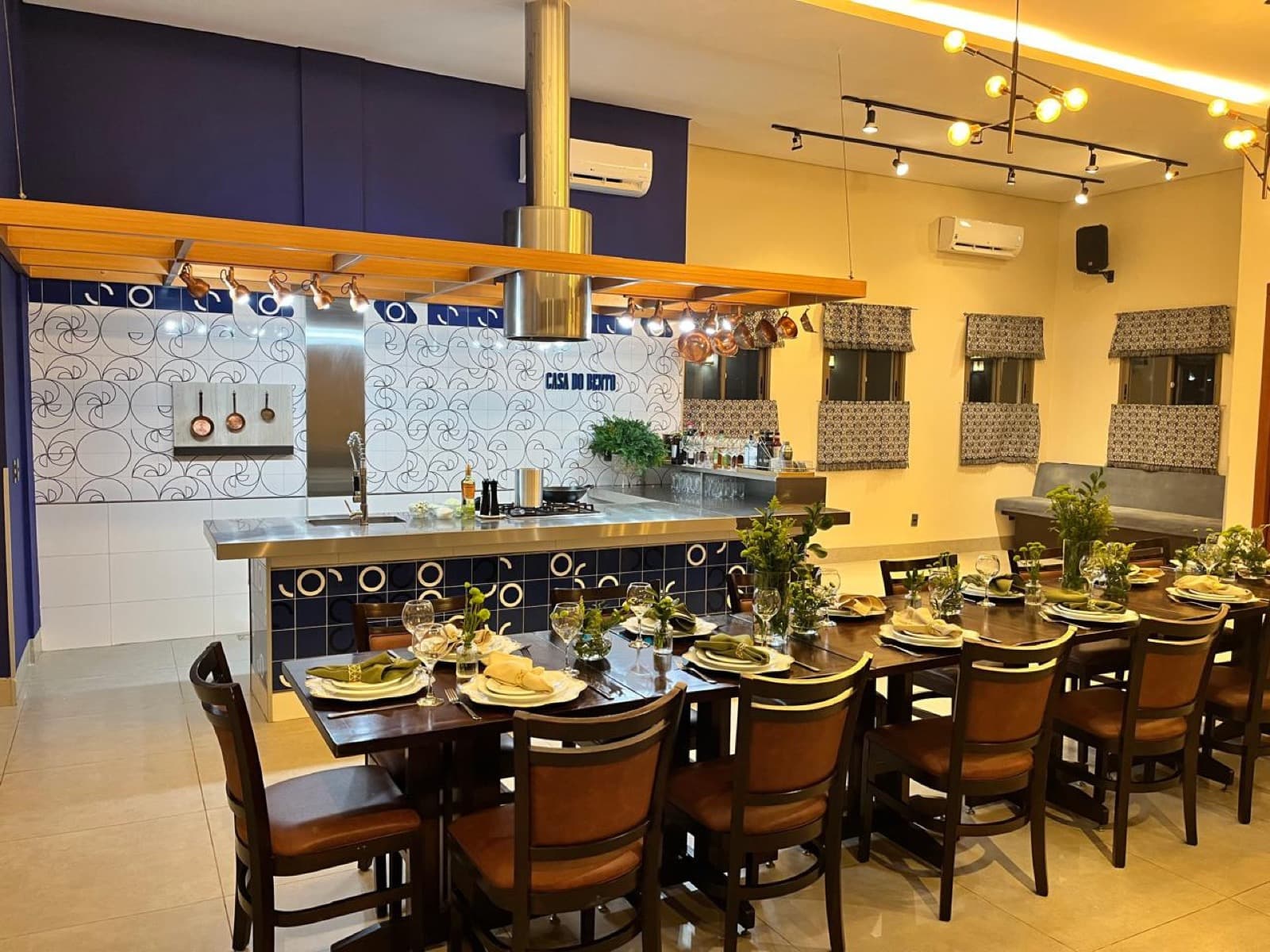 Salão amplo da Casa do Bento com mesas organizadas e iluminação acolhedora